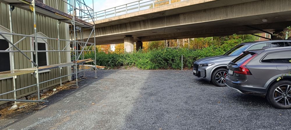 Del av byggnaden med grusad infart och häck närmast Frösöbron som syns i förgrunden.